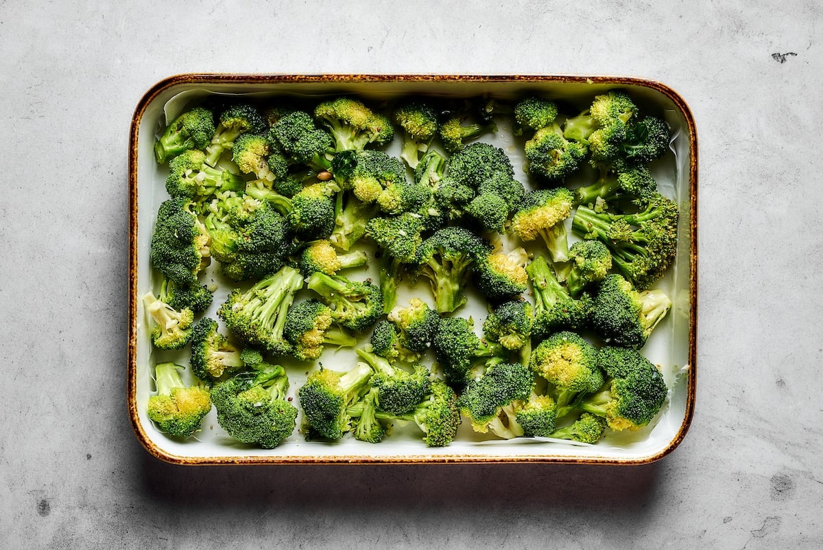 Easy roasted broccoli with garlic is destined to be your new go-to side dish! This crispy, oven-baked broccoli recipe is even kid-approved. Broccoli florets on a metal baking sheet.