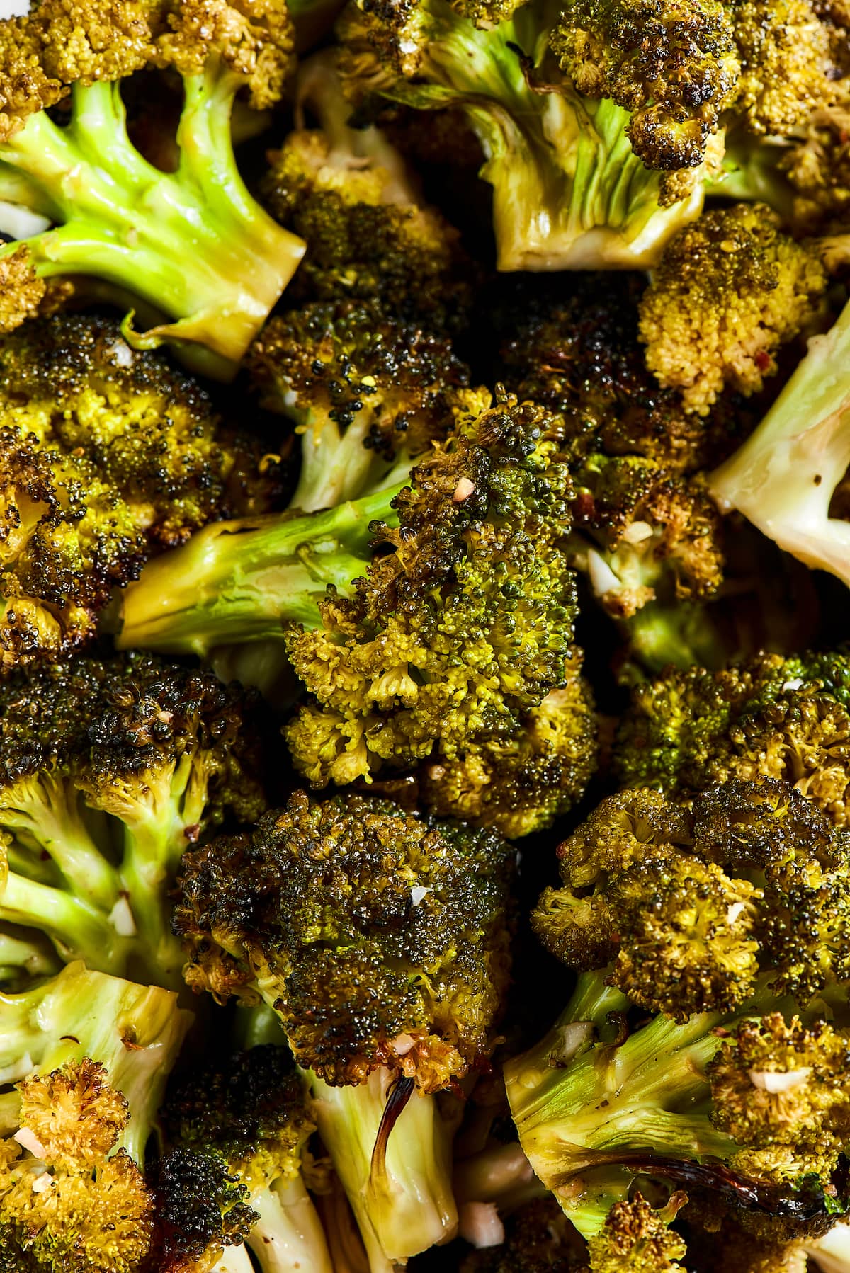 Easy roasted broccoli with garlic is destined to be your new go-to side dish! This crispy, oven-baked broccoli recipe is even kid-approved. Close up of perfectly roasted broccoli.
