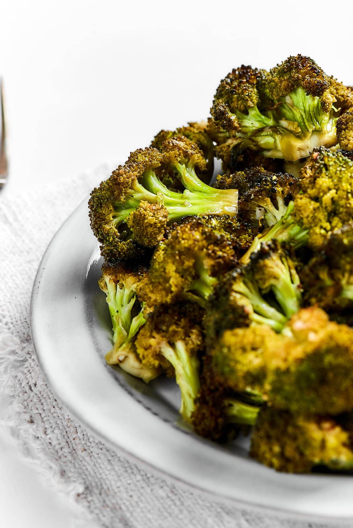Easy roasted broccoli with garlic is destined to be your new go-to side dish! This crispy, oven-baked broccoli recipe is even kid-approved. A bowl of roasted broccoli.
