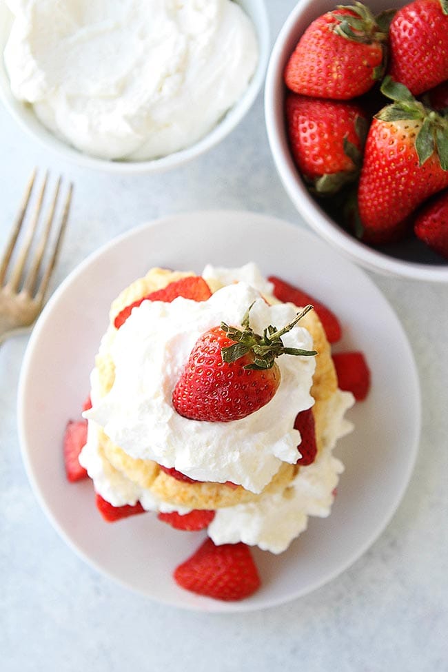 Strawberry Shortcake with juicy strawberries and whipped cream is always a favorite dessert! #strawberry #dessert #biscuits #whippedcream #easydessert #spring #summer top down shot of strawberry shortcake with strawberry on top.
