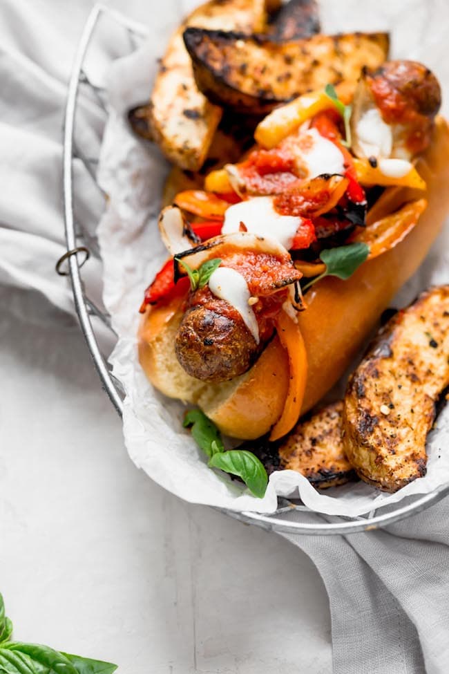 Grilled Italian Sausage And Peppers Served In A Bun And Topped With Marinara Sauce, Melted Mozzarella Cheese, And Fresh Basil. The Perfect Easy Summer Dinner! #summer #grilling #sausage #grilled #easyrecipe #dinner #easydinner #cheese #summer #bbq Grilled Italian Sausage and Peppers Recipe