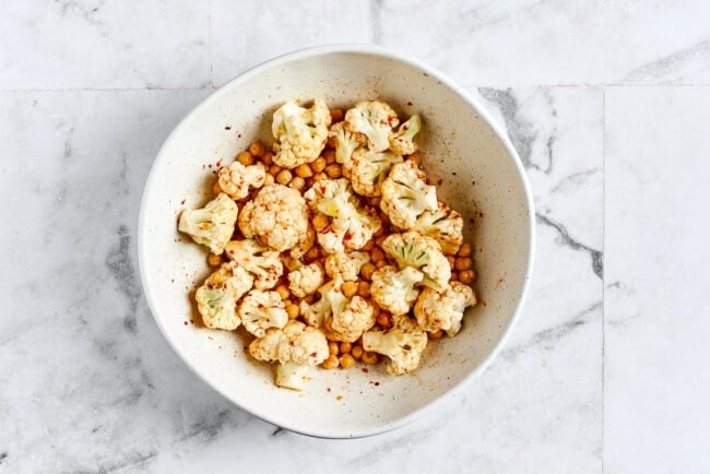 These roasted cauliflower and chickpea tacos are spicy, fresh, bursting with flavor, and a healthy vegetarian Mexican dinner A bowl of cauliflower and chickpeas tossed with olive oil, lime juice, cumin, chili powder, onion powder, garlic powder, and salt