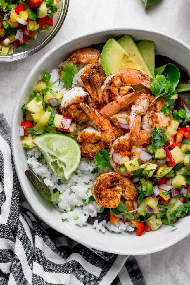 Shrimp Bowls With Coconut Cilantro Lime Rice And Pineapple Salsa Can Be On The Dinner Table In 30 Minutes! This Refreshing And Simple Meal Is A Summer Favorite! #shrimp #recipe #bowls #glutenfree #salsa #dinner #easydinner #shrimprecipe #healthyrecipe #easyrecipe Shrimp Bowl with pineapple salsa, coconut cilantro lime rice, and avocado.