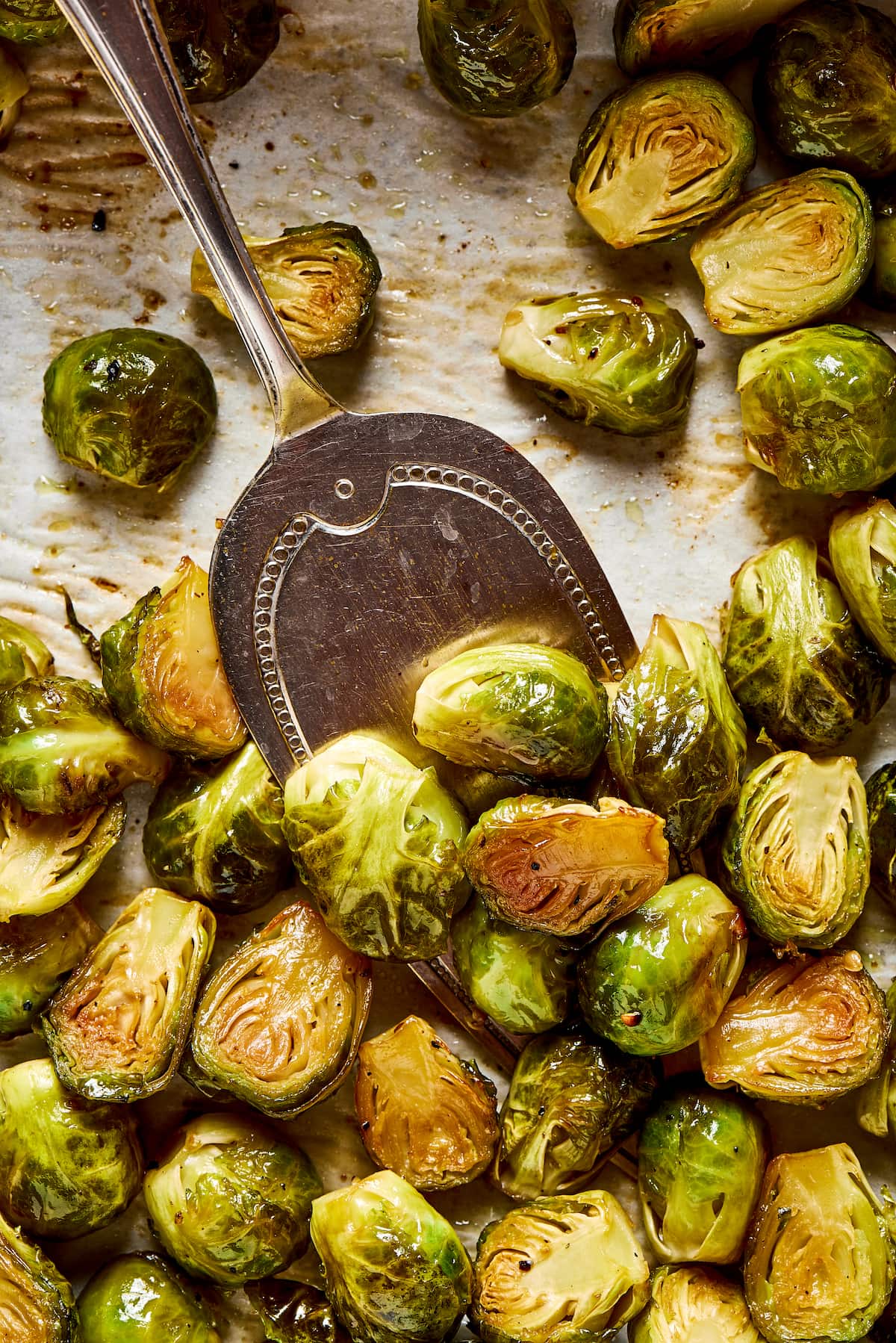 This roasted brussels sprouts recipe uses balsamic vinegar for an easy and flavorful Italian side dish that's healthy and vegetarian. Close up of a serving spoon scooping some roasted Brussels sprouts