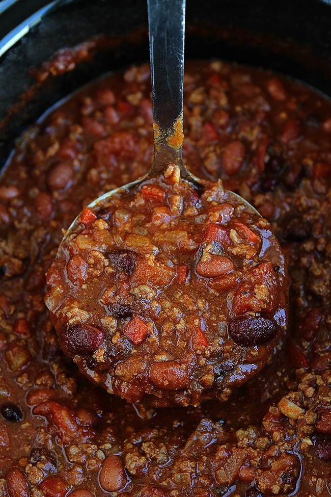 This easy Slow Cooker Beef Chili is a family favorite! Get out the crockpot and make it for dinner today! #chili #slowcooker #crockpot #dinner #easyrecipe #chilirecipe #fall #winter #gameday #glutenfree chili in ladle in slow cooker.