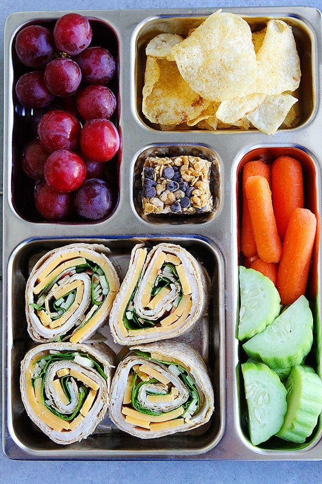 Turkey Cheddar Apple Pinwheels-Turkey, Cheddar Cheese, Spinach, Apple, And Mustard Get Rolled Up In Whole Wheat Tortillas And Cut Into Bite Size? Pinwheels. These Easy Turkey Pinwheels Make A Fun And Delicious Lunch, Snack, Or Party Appetizer. #turkey #pinwheels #backtoschool #lunchbox #lunchboxideas #tortilla #cheese #kidfriendly #easyrecipe #schoollunch Turkey Pinwheels in lunch box