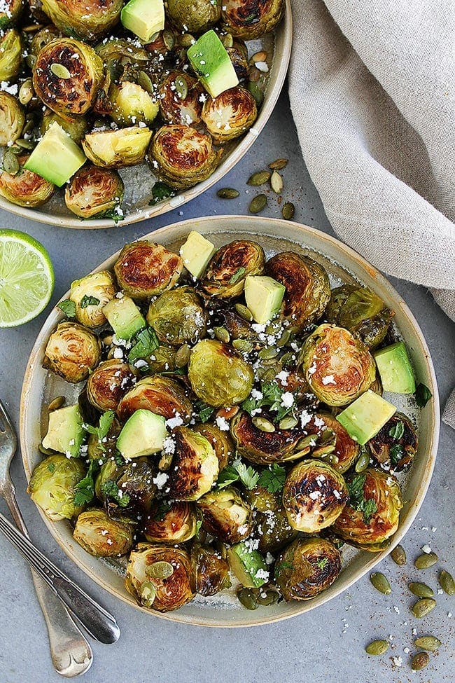 Roasted Brussels Sprouts With A Simple Honey Lime Dressing, Spiced Pepitas, Avocado, Cilantro, And A Sprinkling Of Cotija Cheese. This Easy Brussels Sprouts Recipe Is A Great Side Dish For The Holidays Or Any Day! #brusselssprouts #holiday #Christmas #Thanksgiving #sidedish #glutenfree #vegetarian #healthyrecipe Honey Lime Roasted Brussels Sprouts with Avocado