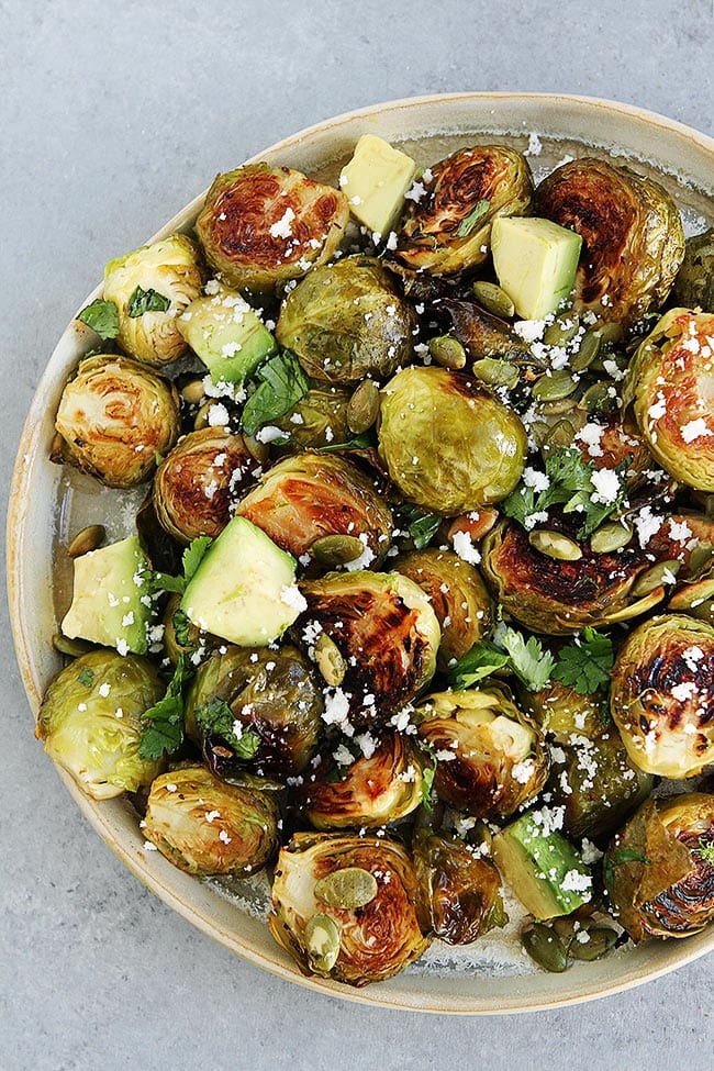 Roasted Brussels Sprouts With A Simple Honey Lime Dressing, Spiced Pepitas, Avocado, Cilantro, And A Sprinkling Of Cotija Cheese. This Easy Brussels Sprouts Recipe Is A Great Side Dish For The Holidays Or Any Day! #brusselssprouts #holiday #Christmas #Thanksgiving #sidedish #glutenfree #vegetarian #healthyrecipe Roasted Brussels Sprouts with Honey Lime Dressing and Avocado