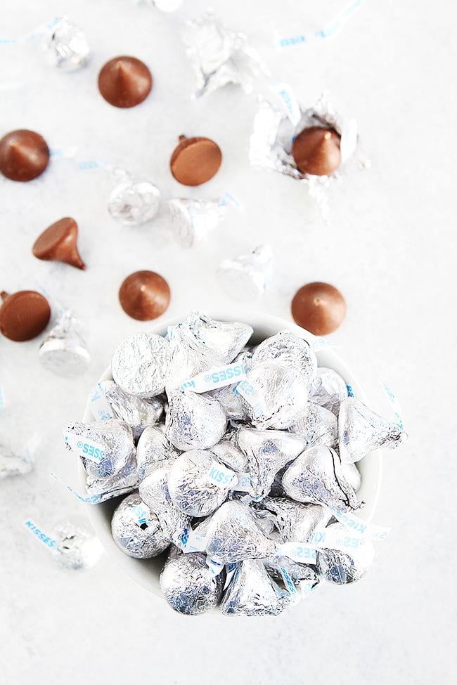 Peanut Butter Blossoms-Soft Peanut Butter Cookies Topped With A Chocolate Kiss Candy In The Center. These Easy Peanut Butter Cookies Are A Holiday Favorite! #cookies #Christmas #Christmascookies #holidays #baking #chocolate #peanutbutter Hershey's Kisses candies in bowl.