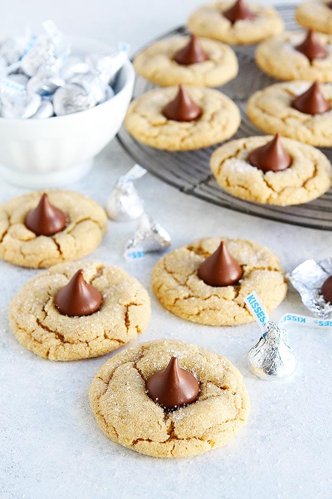 Peanut Butter Blossoms-Soft Peanut Butter Cookies Topped With A Chocolate Kiss Candy In The Center. These Easy Peanut Butter Cookies Are A Holiday Favorite! #cookies #Christmas #Christmascookies #holidays #baking #chocolate #peanutbutter Peanut Butter Blossoms Cookies with Hershey's Kisses in the center.