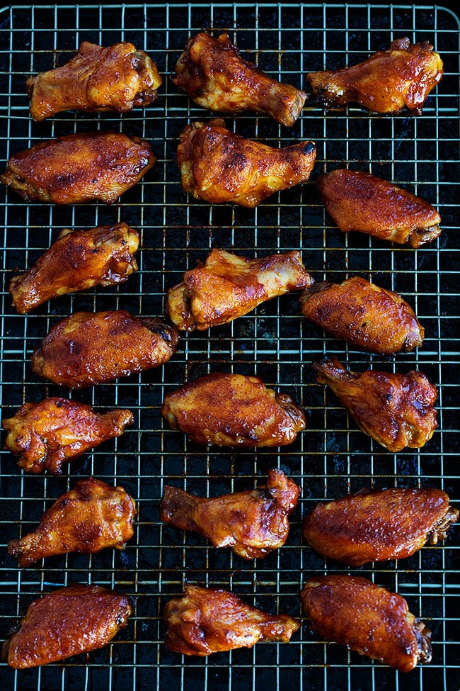 These Easy Baked Chicken Wings With Honey BBQ Sauce Are The Perfect Appetizer For Game Day Or Any Party! They Are A Real Crowd Pleaser, You Will Never Know They Are Baked And Not Fried. #chickenwings #appetizer #wings #superbowl #gameday #football #chickenrecipe Baked Chicken Wings on cooling rack.