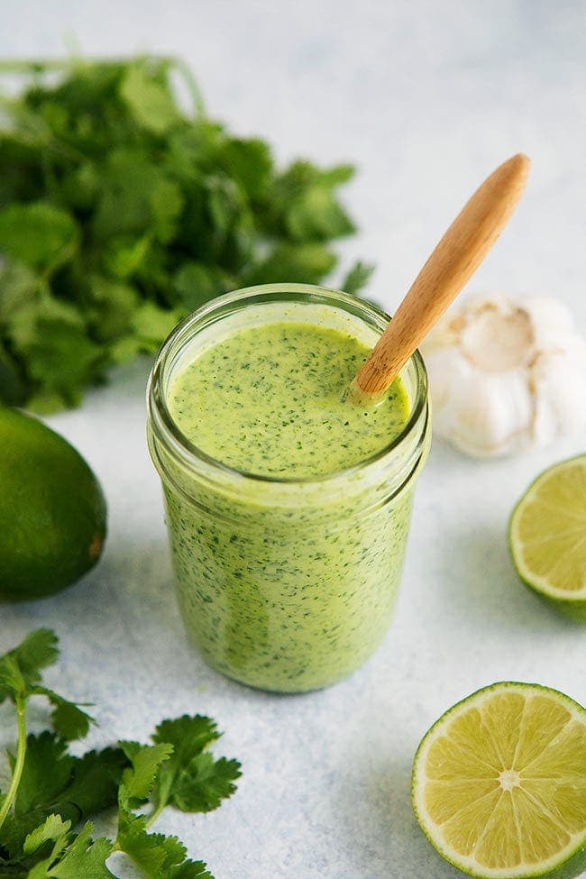 Cilantro Lime Dressing in jar with spoon.