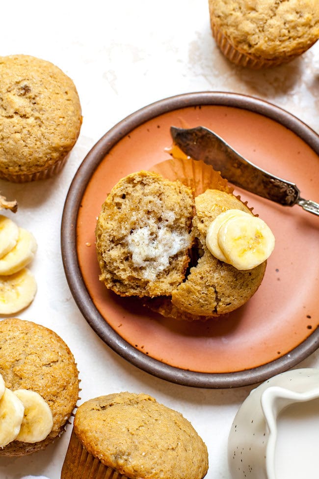 Banana Muffin on plate with butter and bananas.