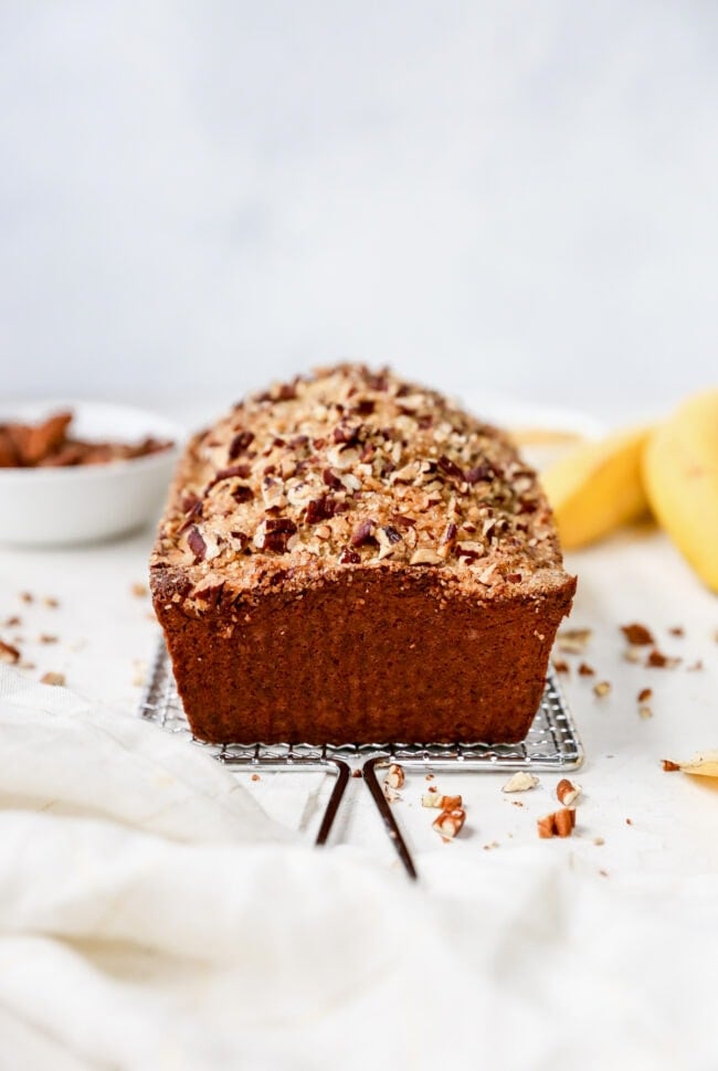 loaf of banana nut bread on cooling rack.