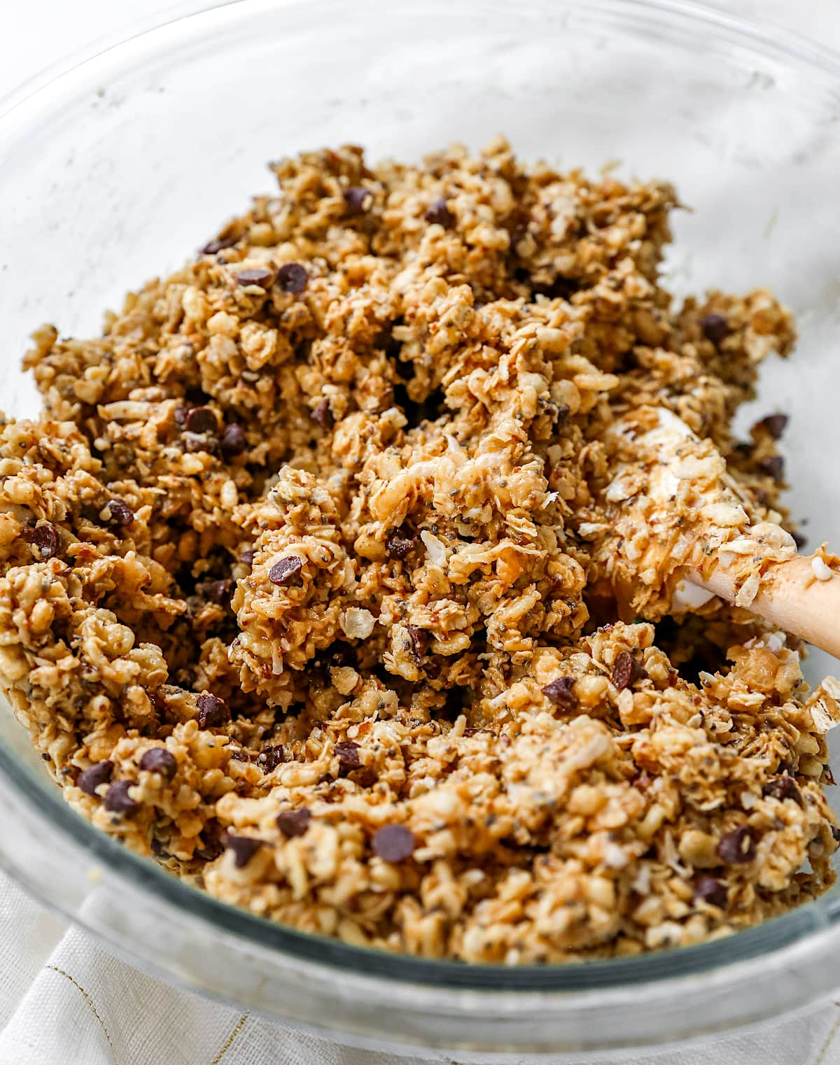Granola bar mixture in bowl with spatula.