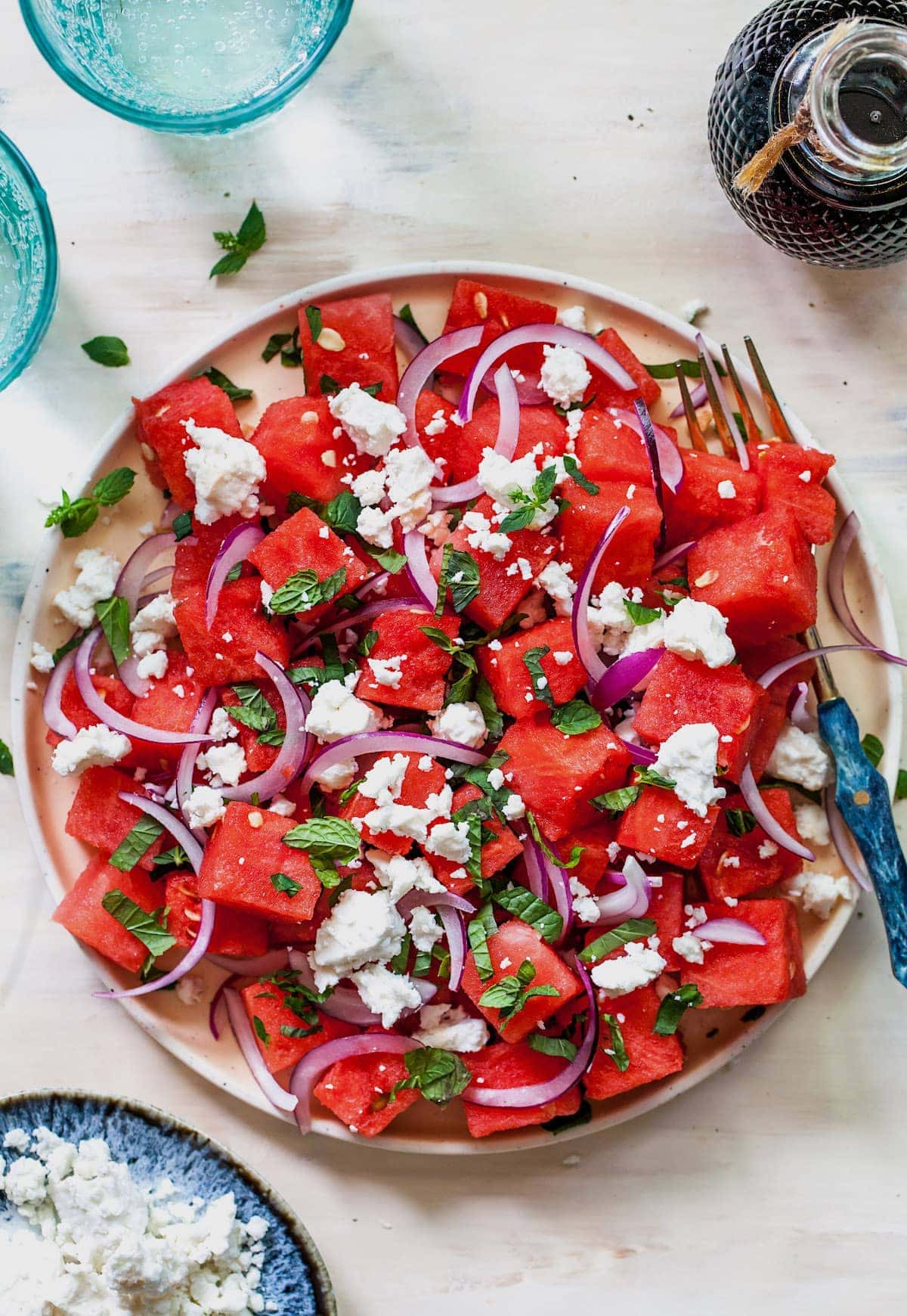 Watermelon Feta Salad with red onion and mint on plate with fork.
