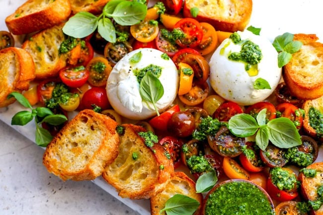 burrata with tomatoes, pesto, and grilled bread with fresh basil