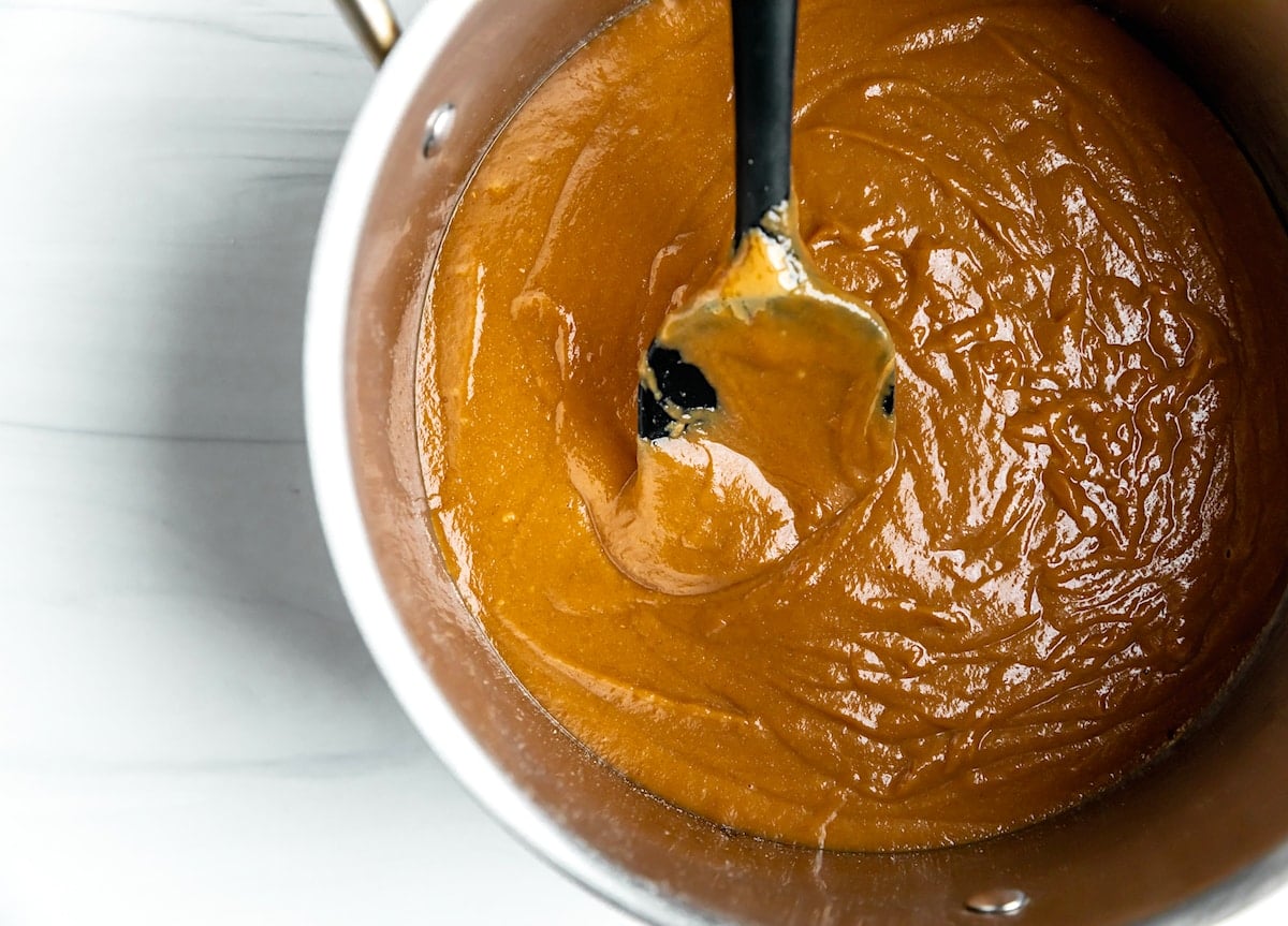 scotcheroo peanut butter corn syrup mixture in pan with spoon.