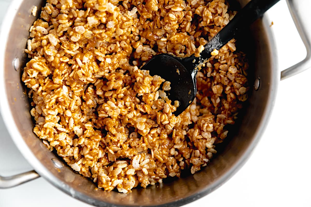 scotcheroo mixture in pan with spoon.