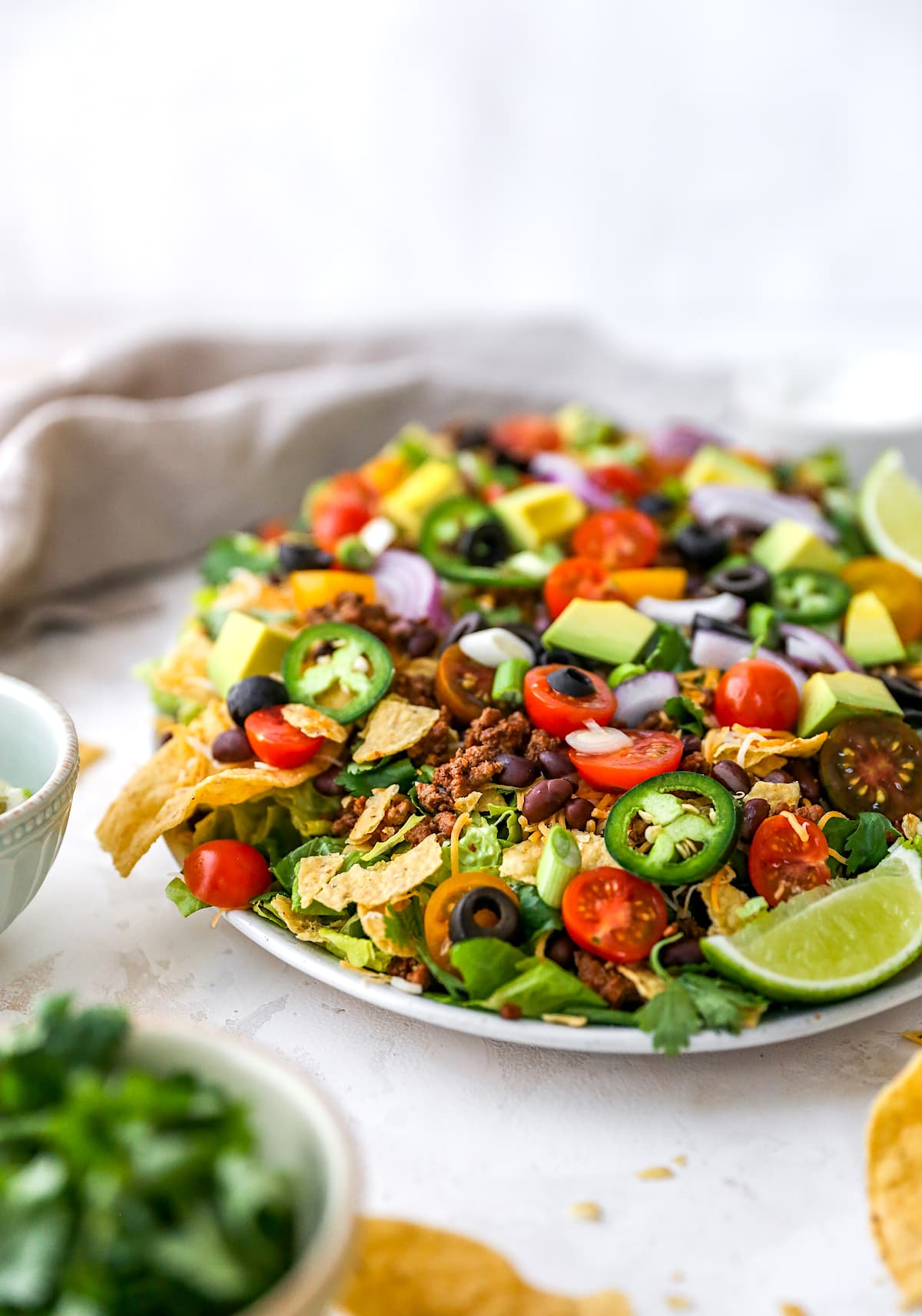 taco salad on platter with toppings and chips.