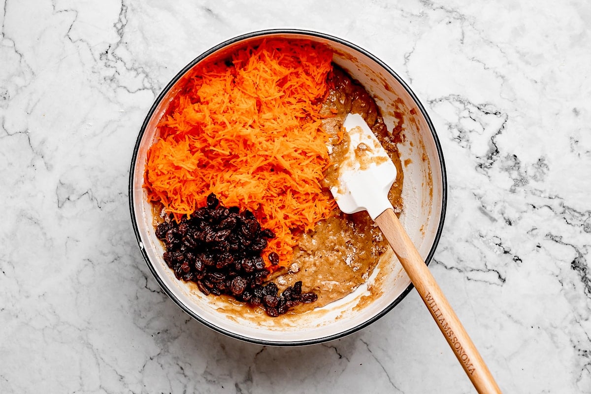 carrot cake muffin batter with shredded carrots and raisins.
