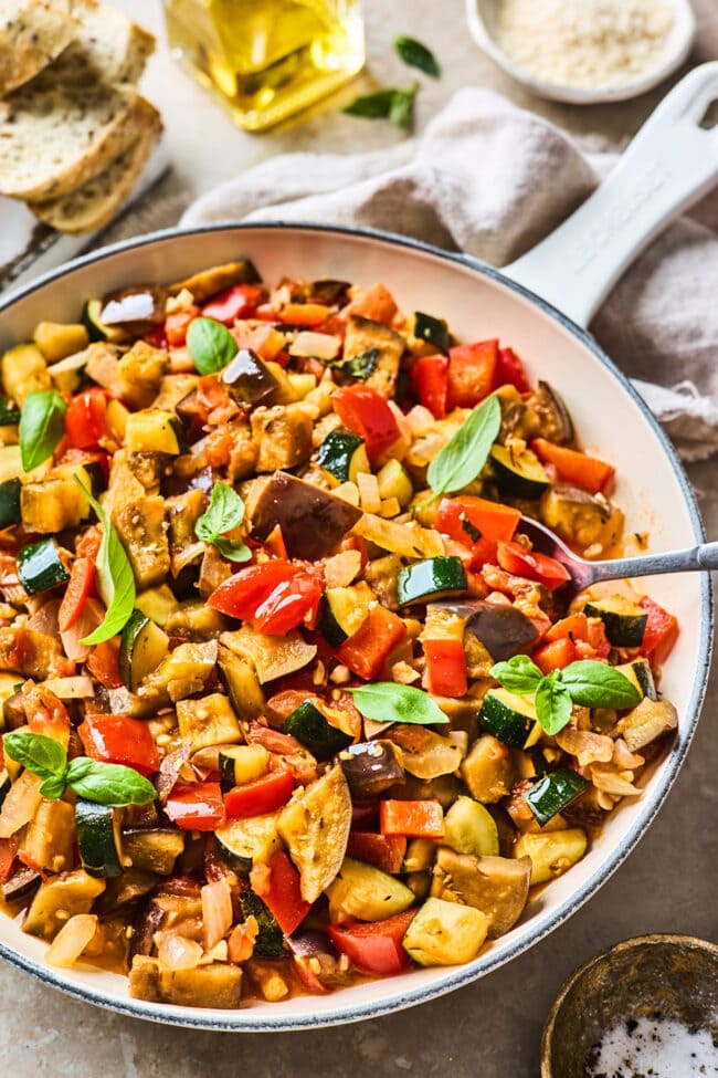 ratatouille in skillet with spoon.
