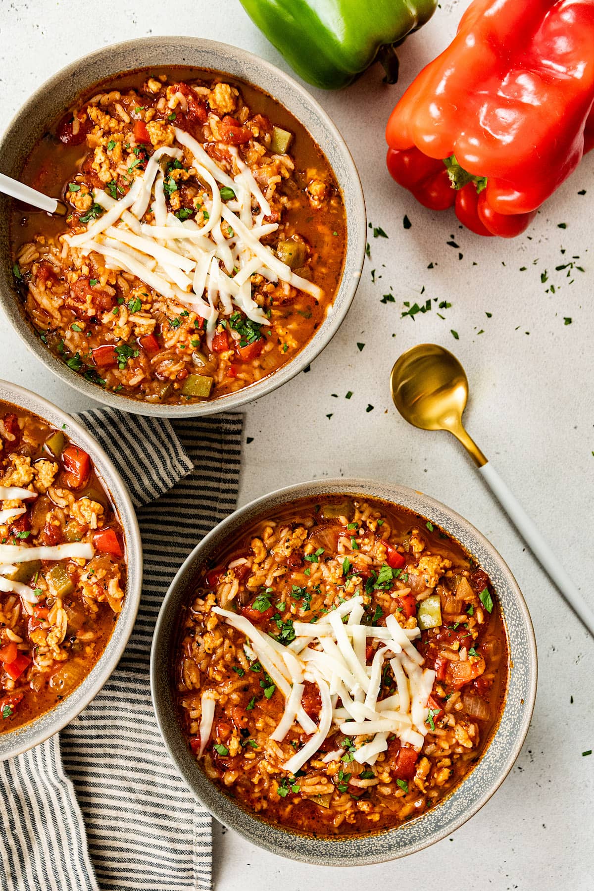 Stuffed Pepper Soup in bowls with shredded cheese and parsley.