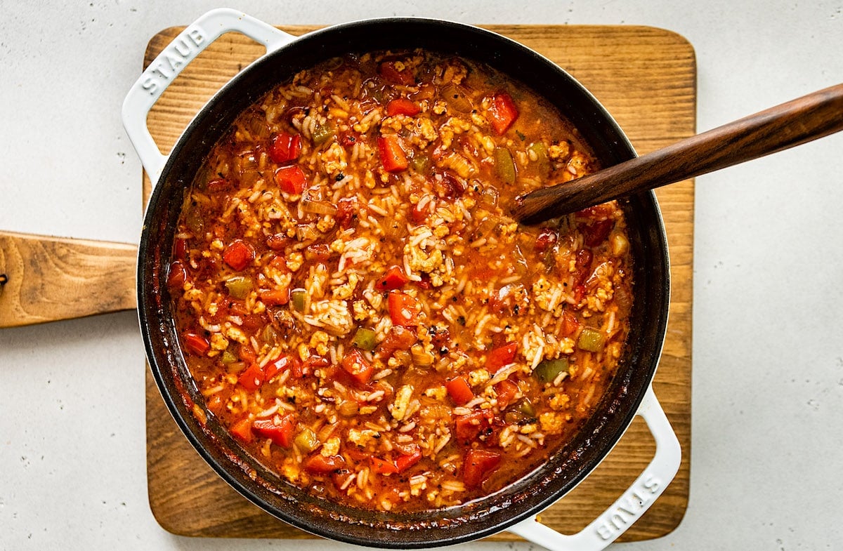 stuffed pepper soup in white pot with wooden spoon.