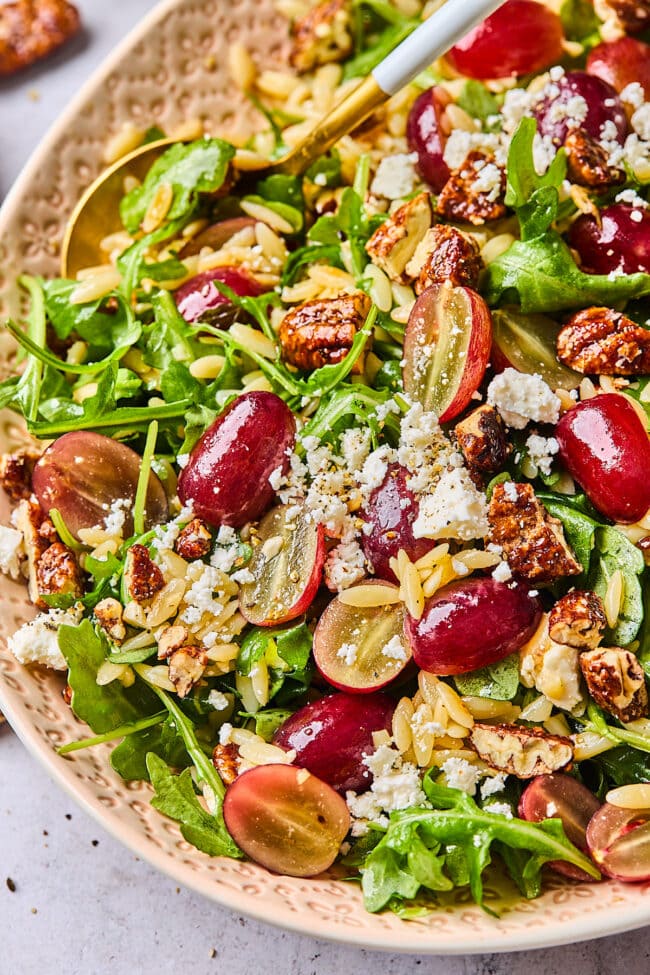 orzo salad with grapes, arugula, feta cheese, and candied pecans.