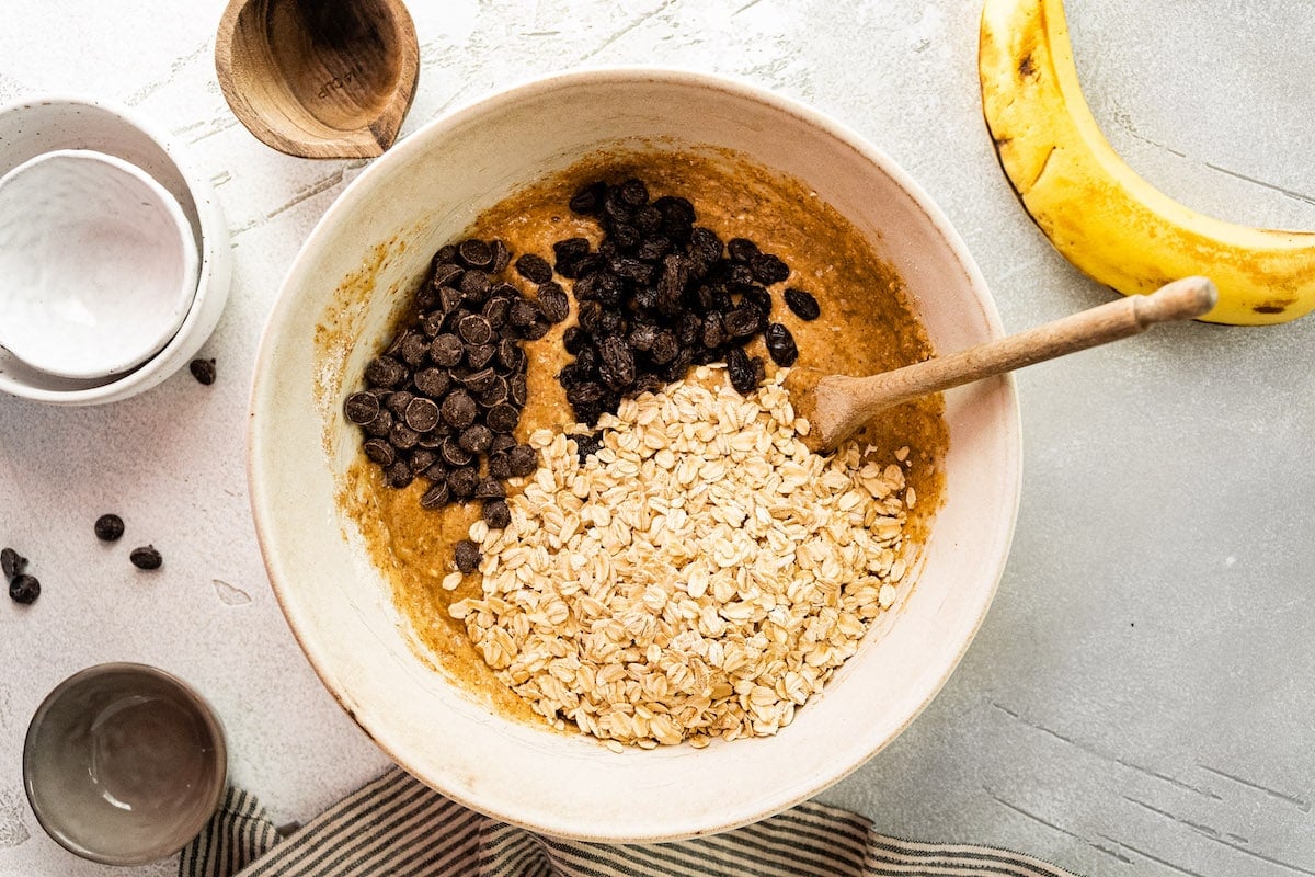 breakfast cookie ingredients in mixing bowl with wooden spoon.