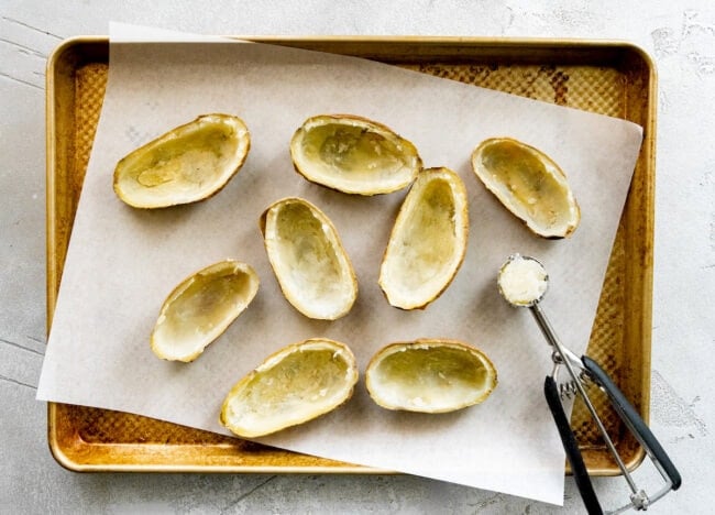 russet potatoes hollowed out on baking sheet to make twice baked potatoes