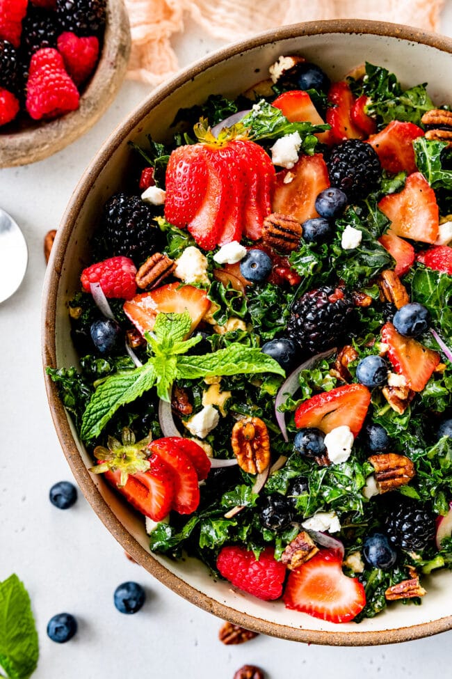 berry kale salad in bowl with fresh mint.