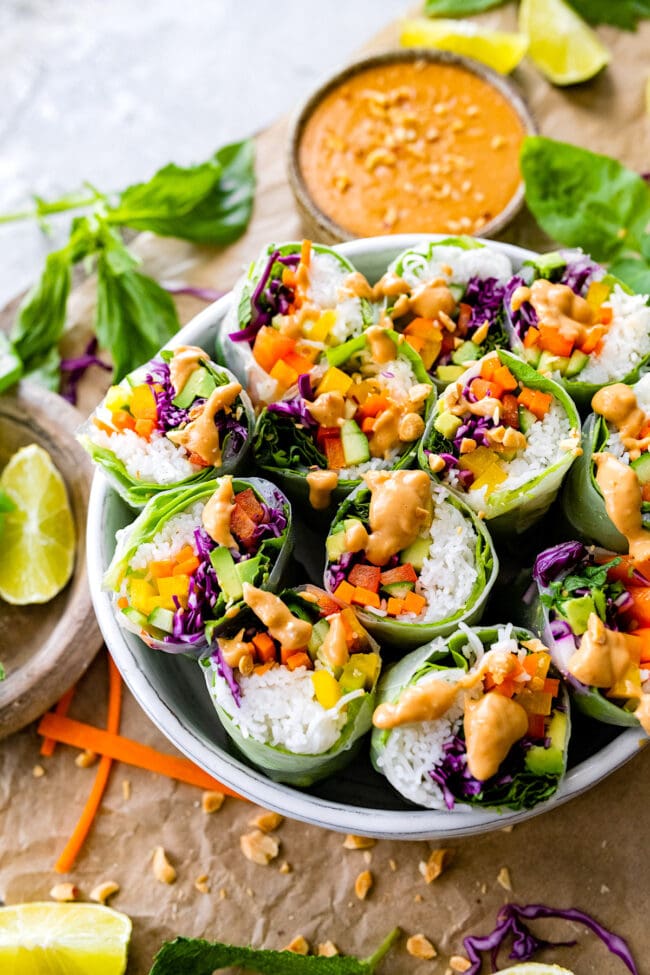 fresh spring rolls in bowl with peanut sauce.
