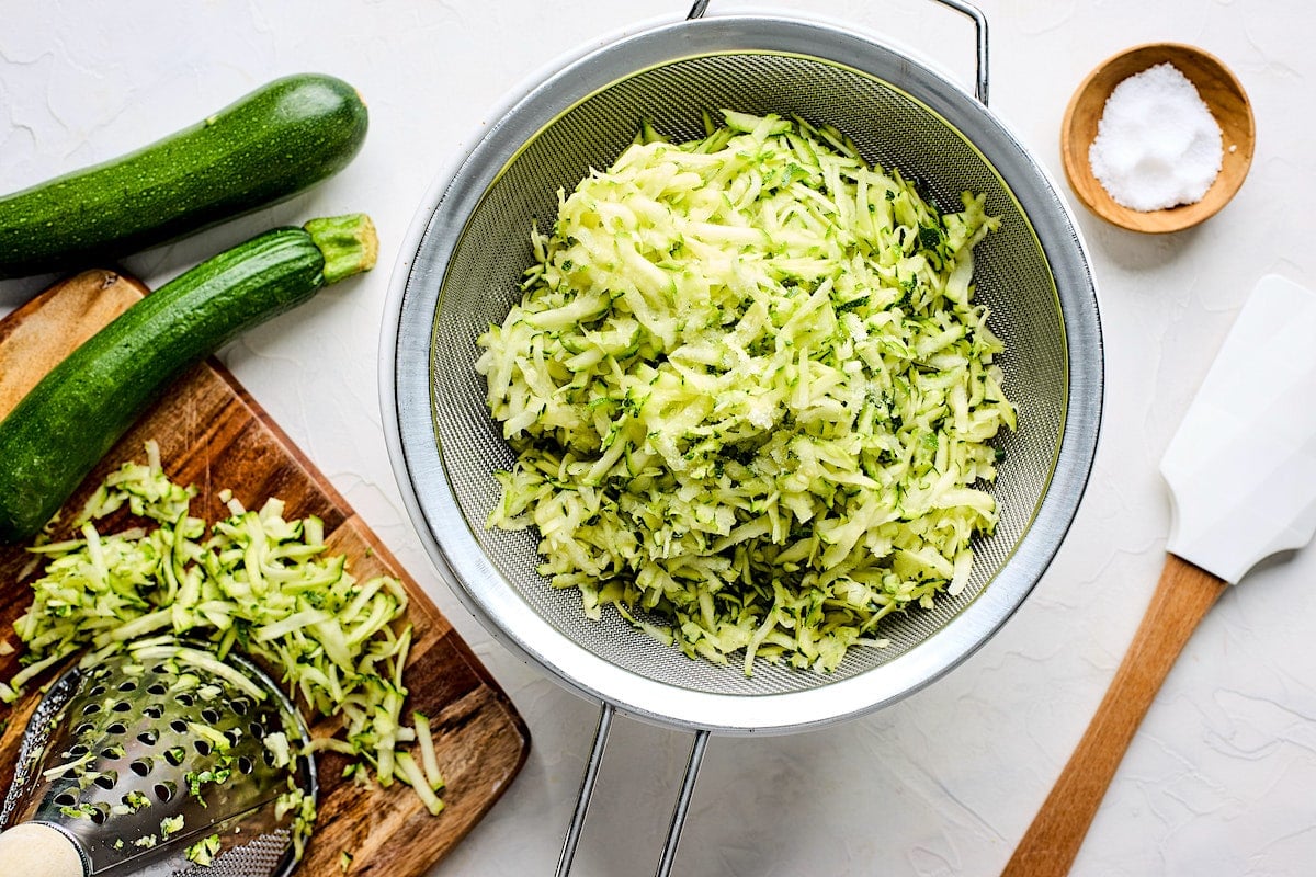 shredded zucchini in colander.