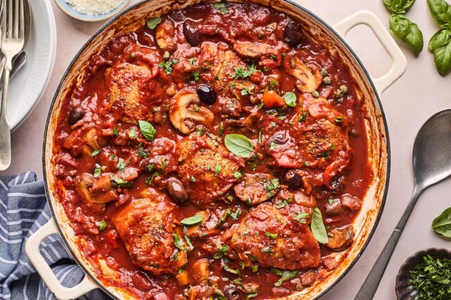 chicken cacciatore in Dutch oven with basil.