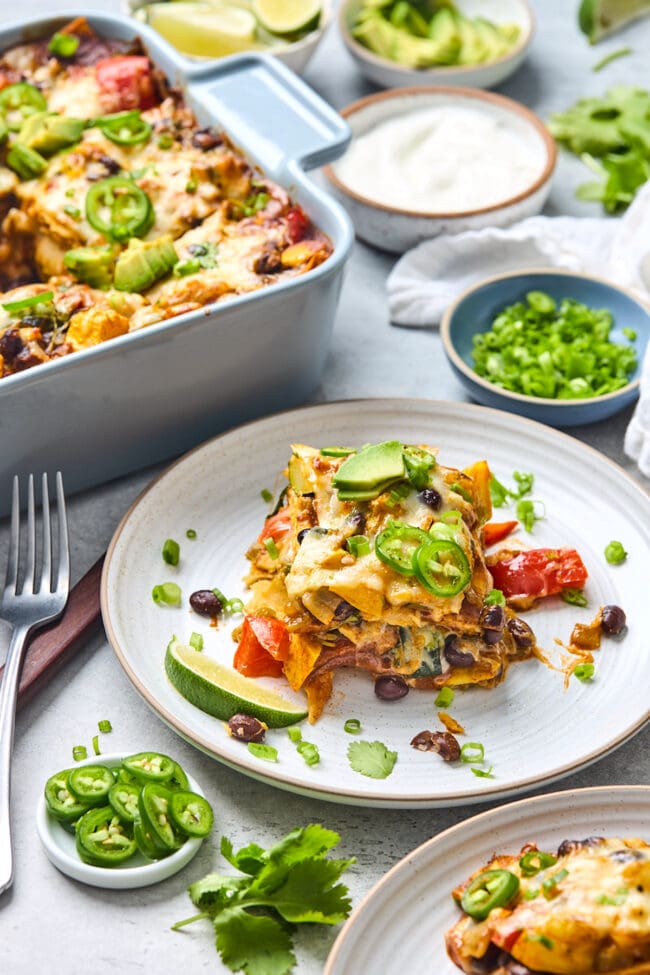 stacked vegetable enchiladas o plate with toppings.