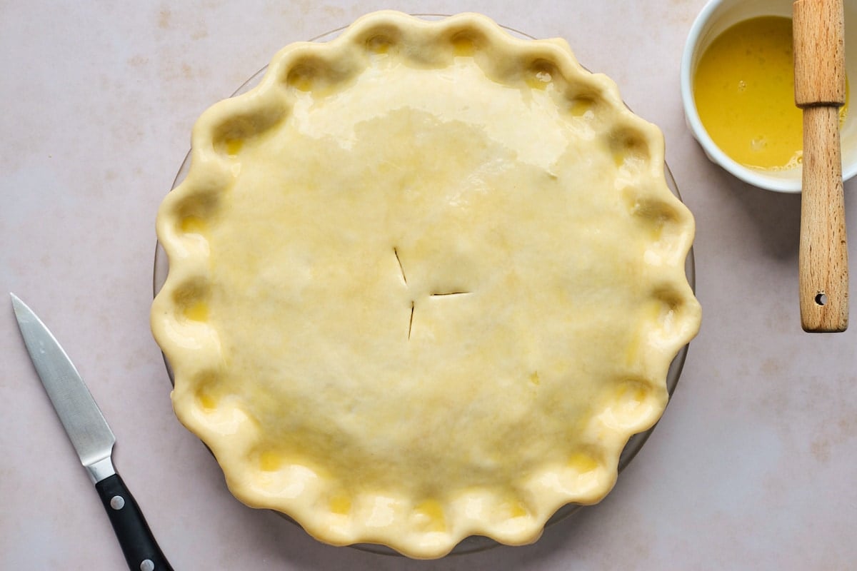 chicken pot pie brushed with egg wash and crimped edges.
