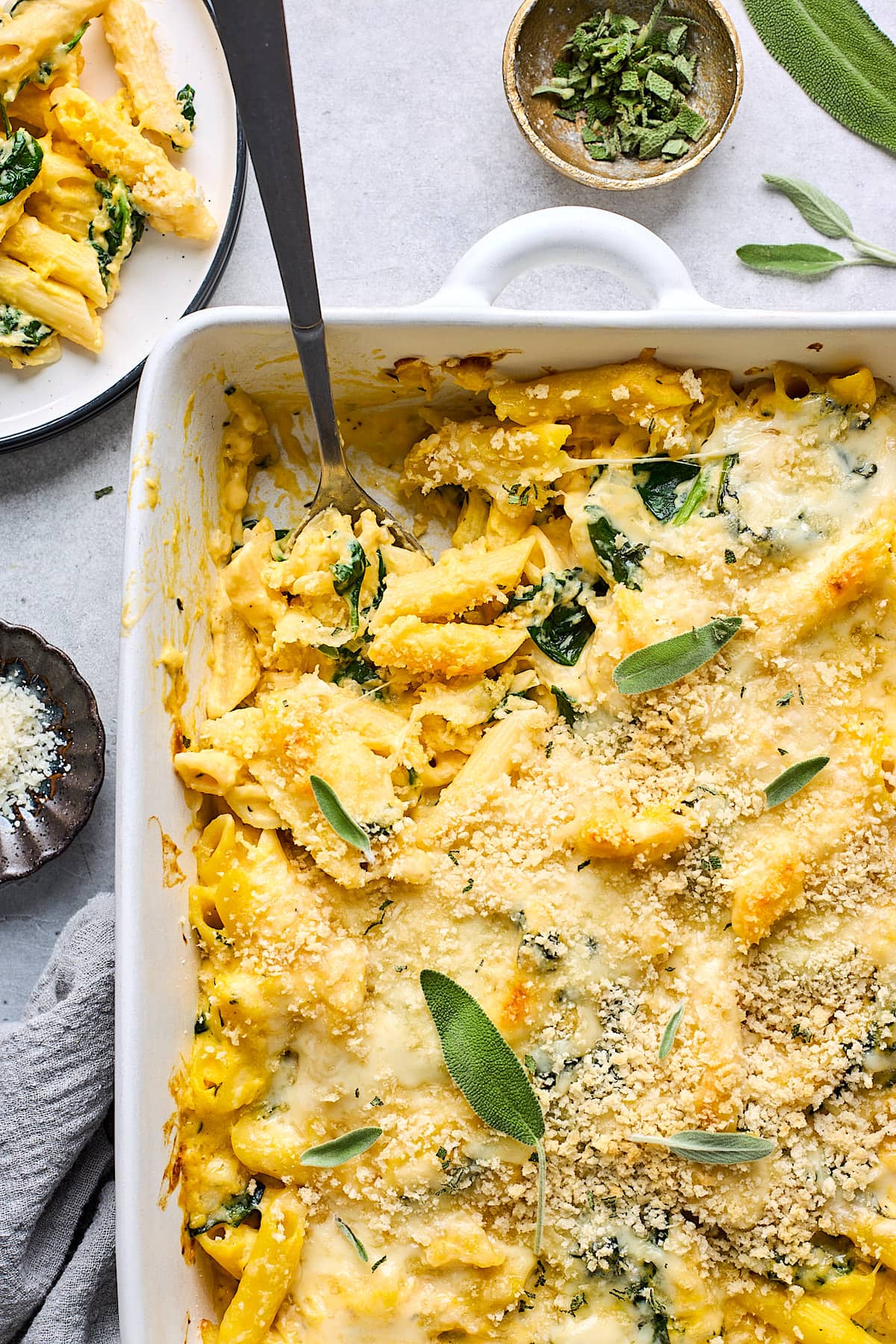 butternut squash baked ziti in baking dish with spoon.