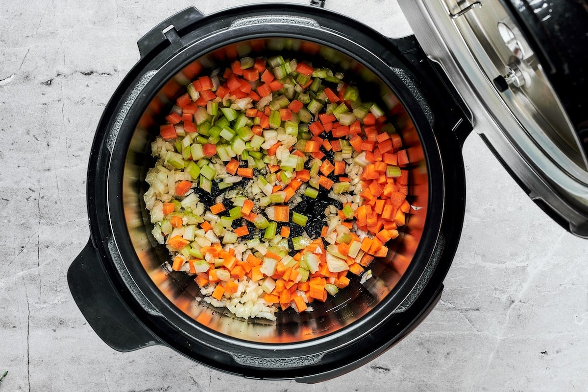 diced onion, carrot, and celery sautéing in Instant Pot.