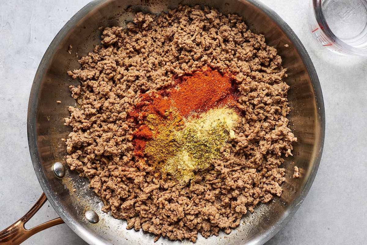 ground beef in skillet with taco seasoning.