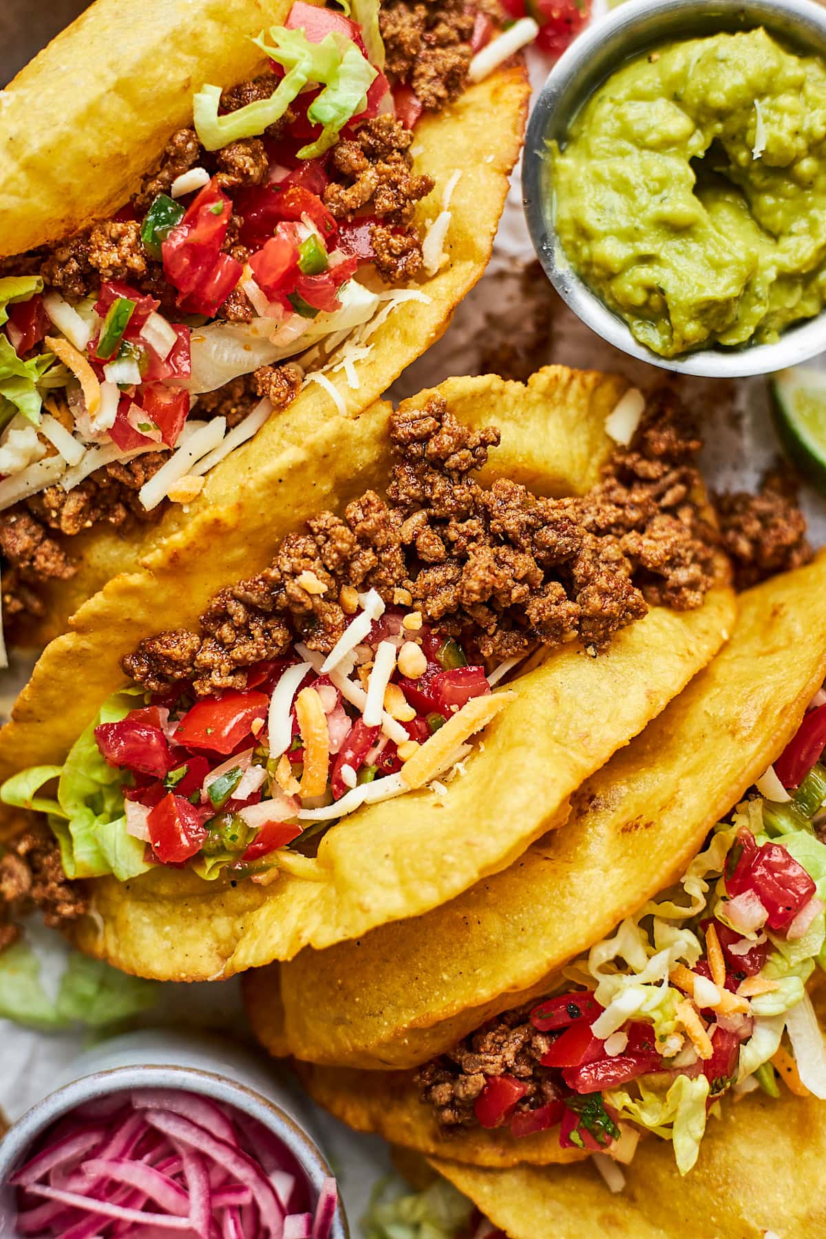 ground beef tacos with tomatoes, cheese, and lettuce in crispy taco shells.