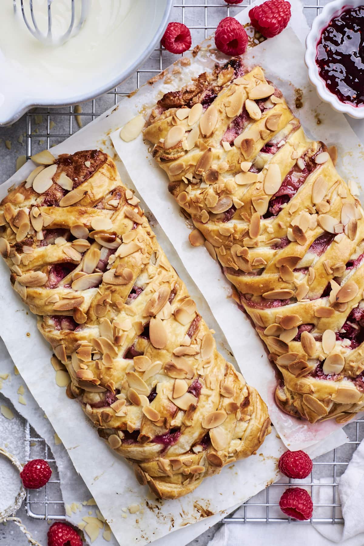 raspberry cream cheese breakfast braids cooling on parchment paper on cooling rack.