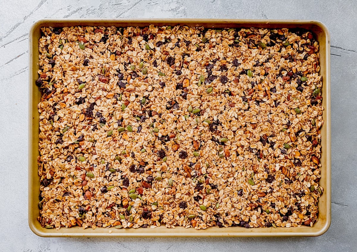 unbaked chocolate chip cookie granola pressed evenly onto a large baking sheet.