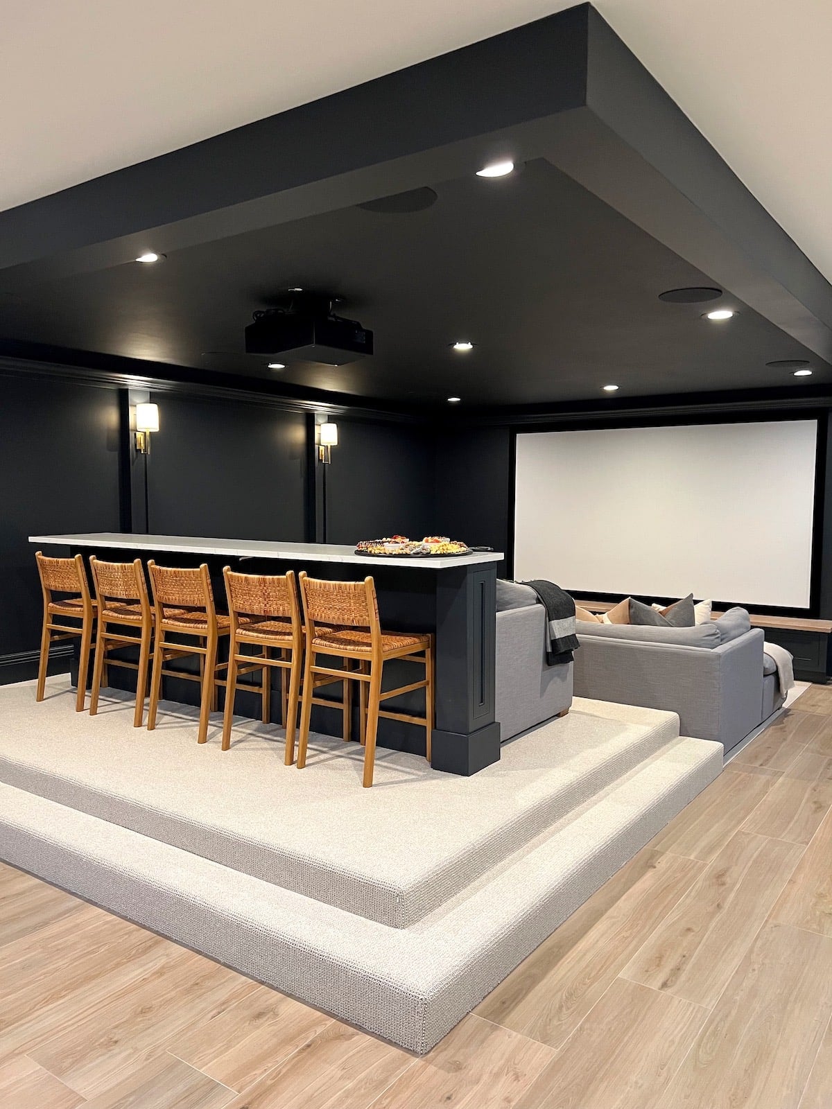 basement theatre room with bar and bar stools.