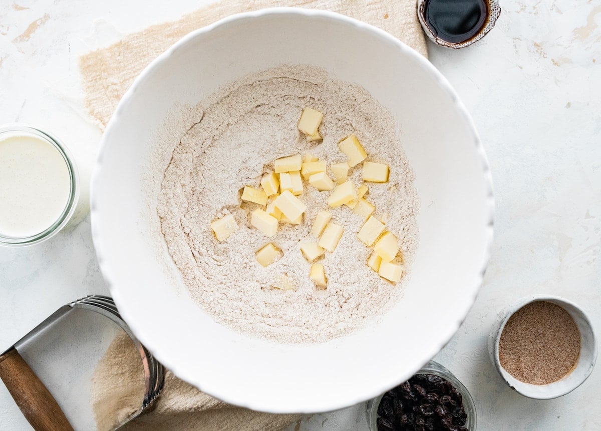cold butter cubes and dry ingredients in mixing bowl to make cinnamon raisin scones.