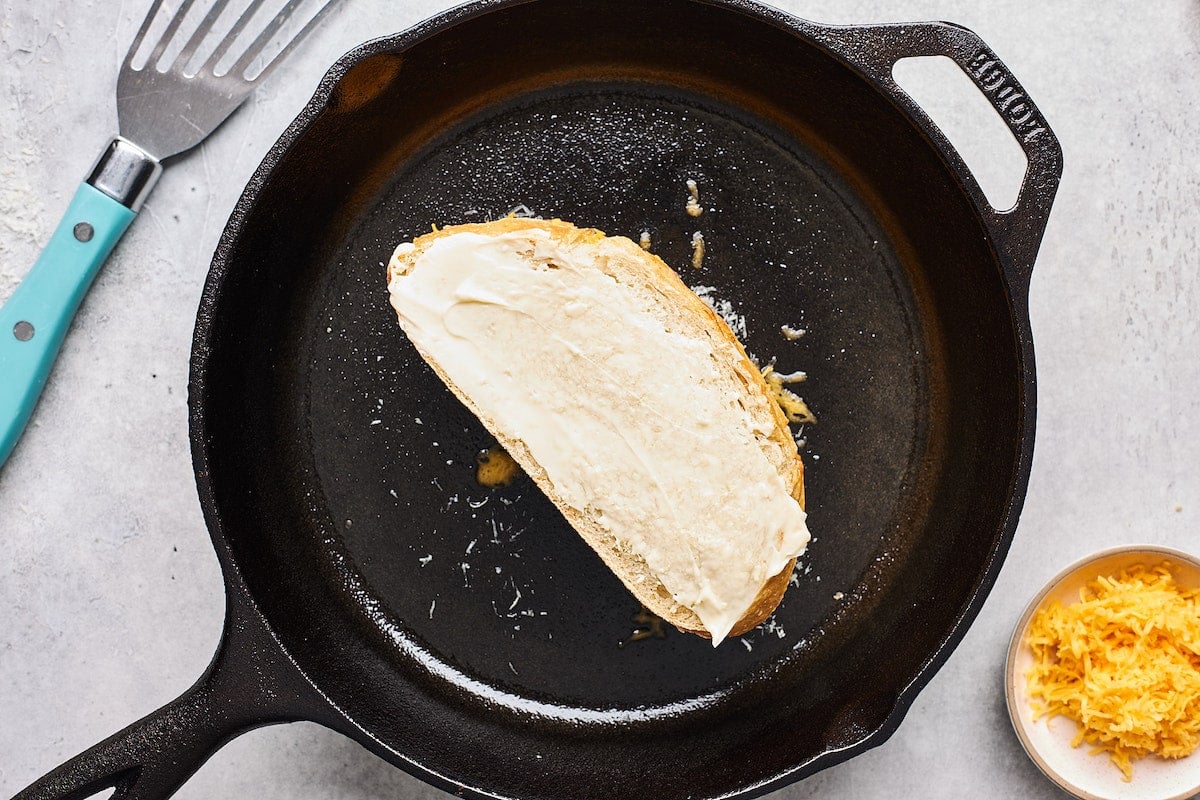 buttered grilled cheese in hot cast iron skillet.