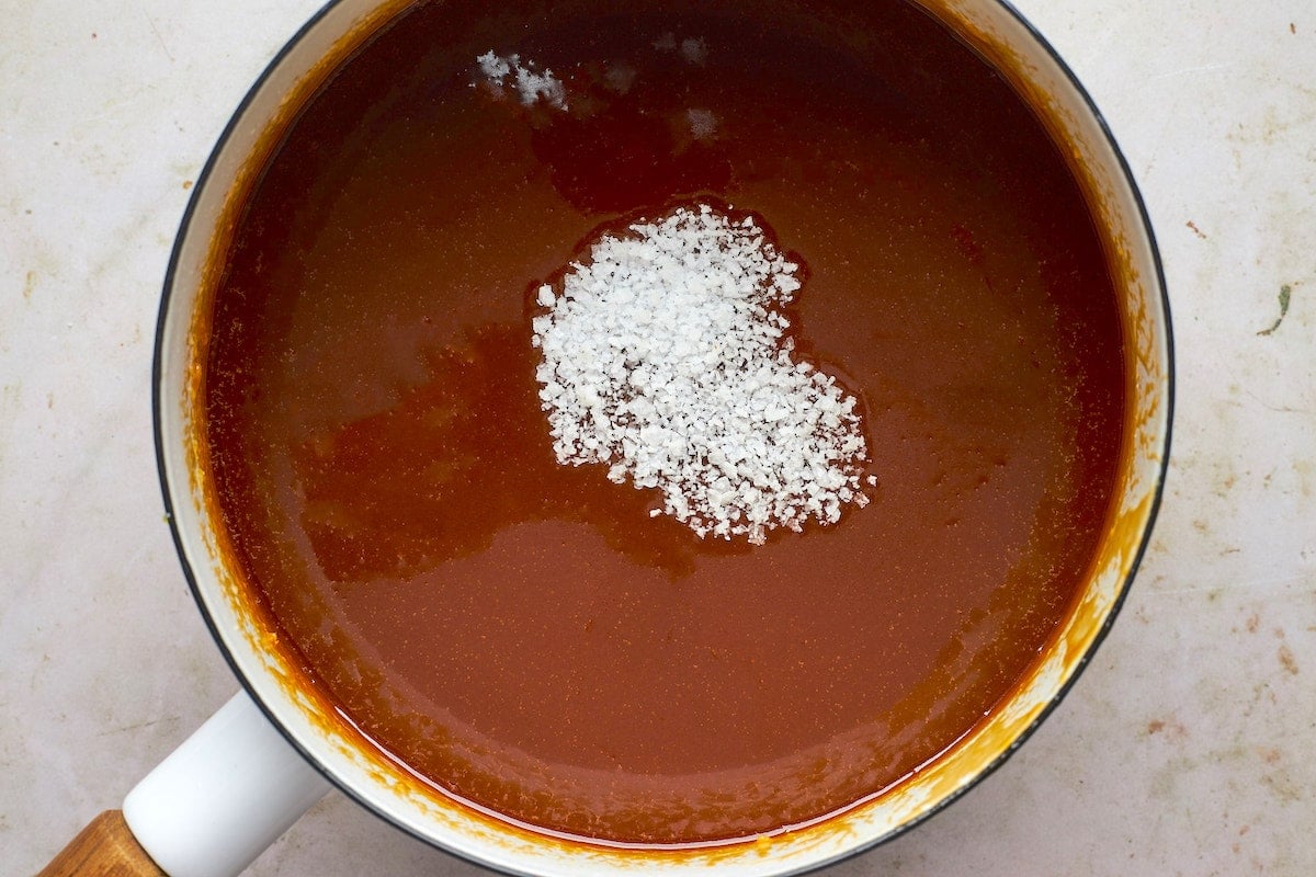 salted caramel sauce in pot with sea salt.