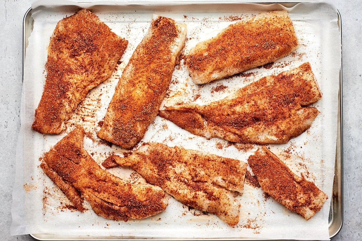 cod with taco seasoning on sheet pan with parchment paper.
