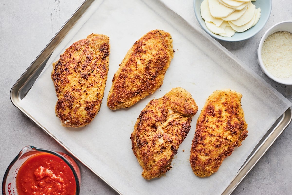 chicken parmesan on baking sheet with parchment paper.