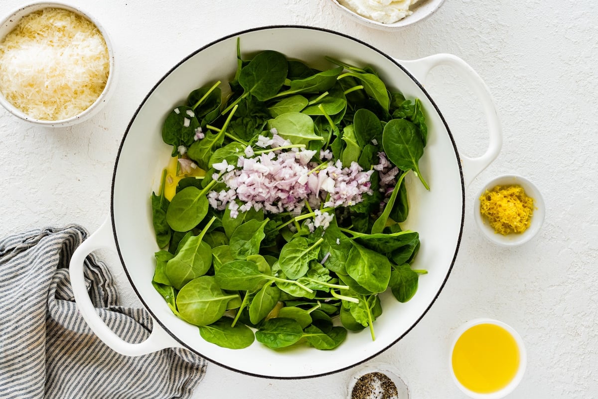 spinach and shallot in large white pot.